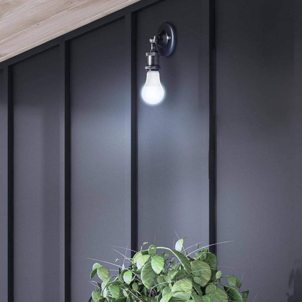 Wall sconce with a glowing LED bulb emitting soft neutral white light.