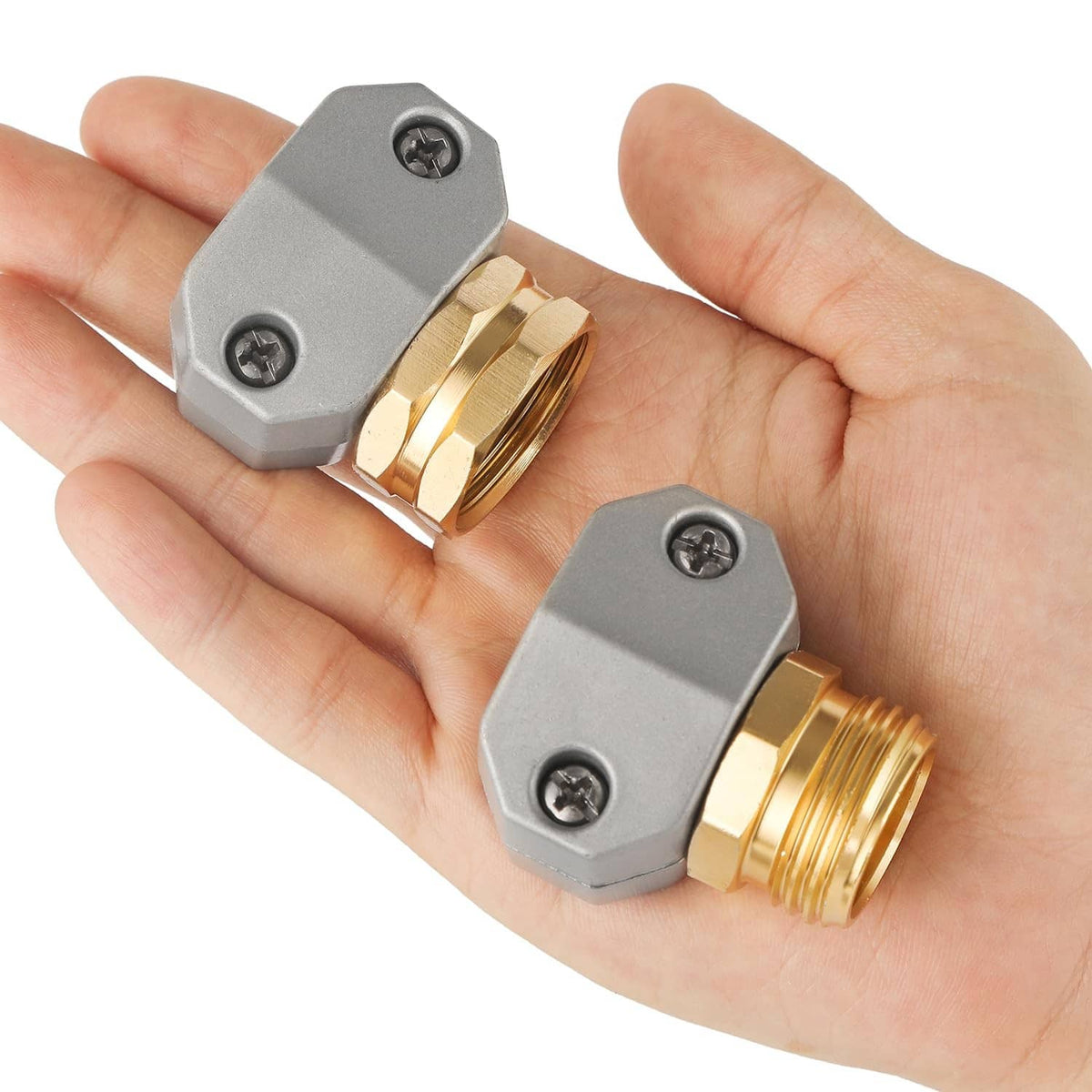 Brass-and-gray garden hose connector pair held in hands for repairing 3/4 or 5/8 hoses
