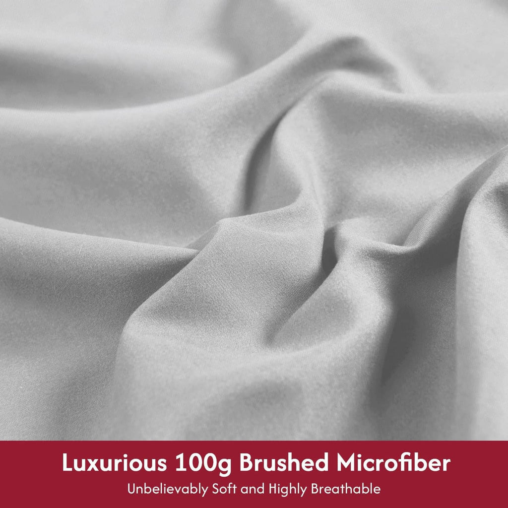 Light gray brushed microfibre sheet fabric close-up with smooth wrinkle texture