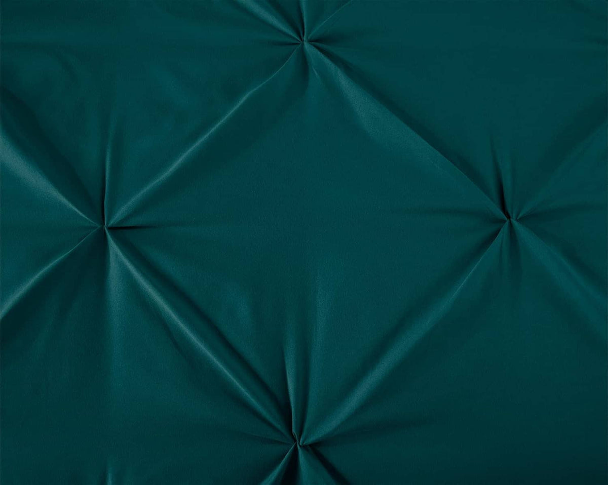 Teal diamond tufted comforter close-up with button-like channel stitching