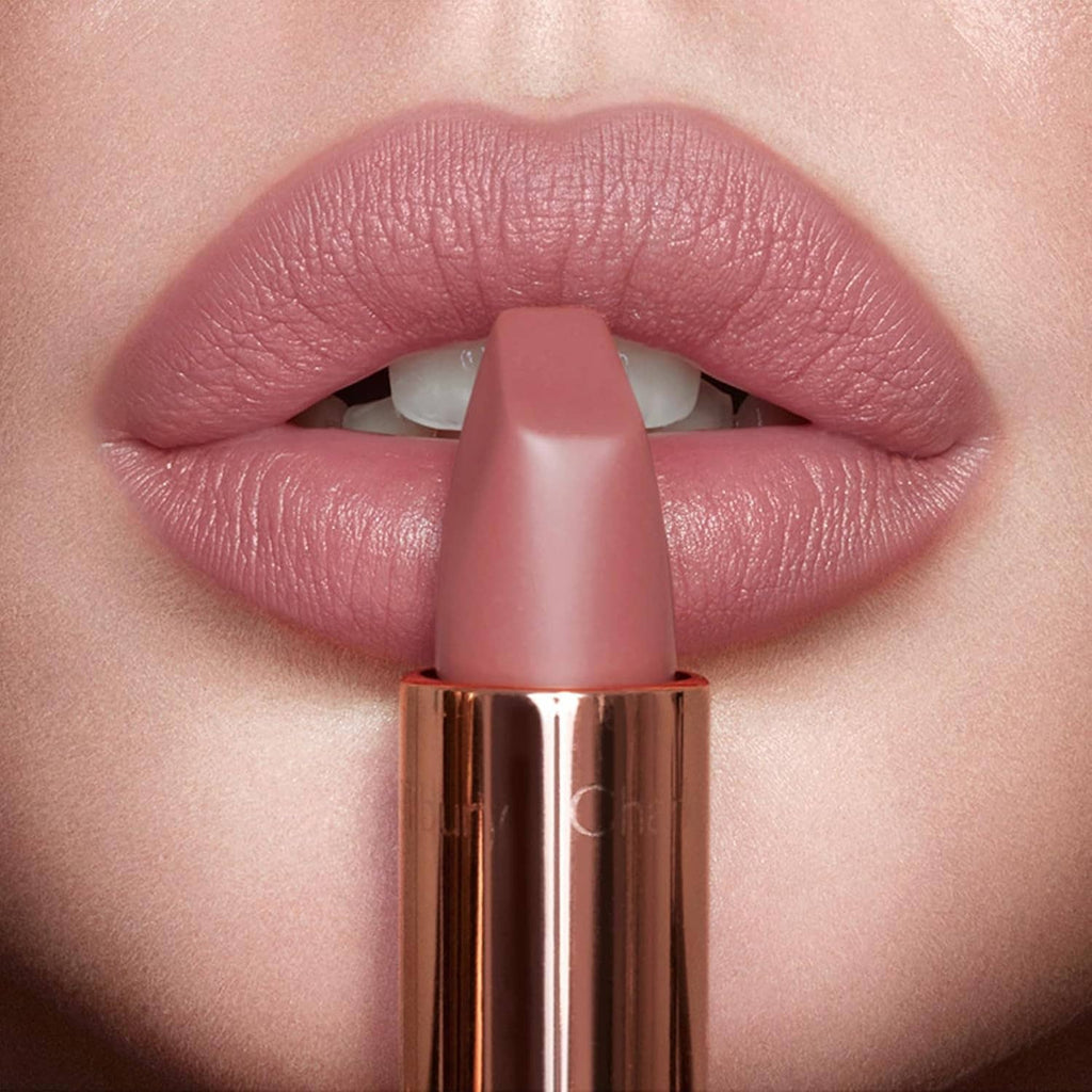 Close-up rose-pink matte lipstick applying to lips, bullet tip centered