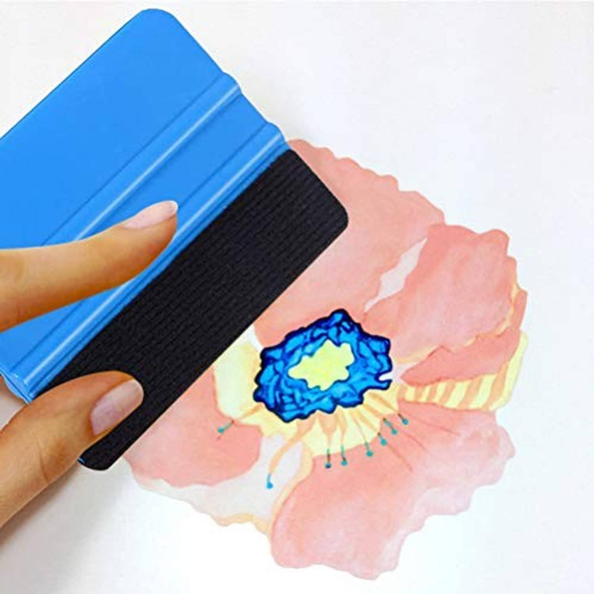 Blue felt edge squeegee with black edge, hand applying to a decorative film strip