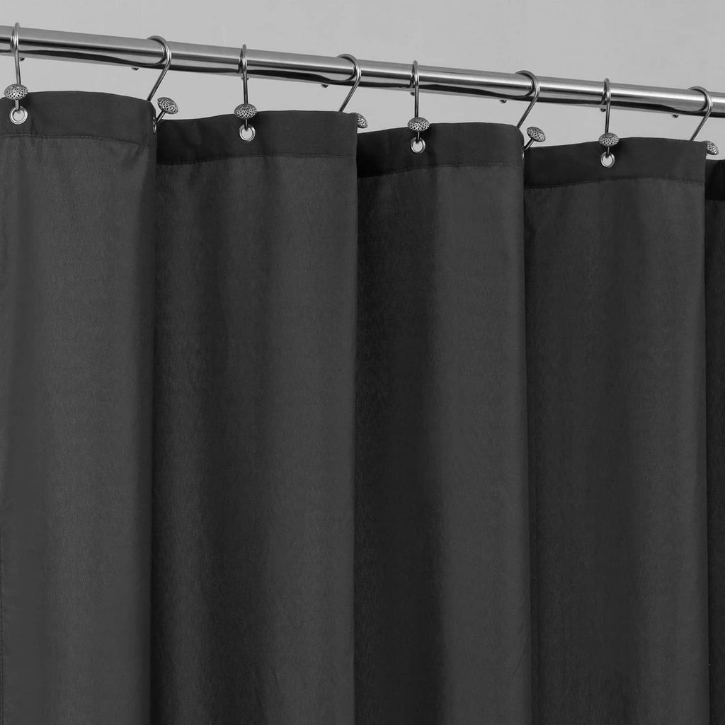 Black fabric shower curtain with hanging hooks along the top rod