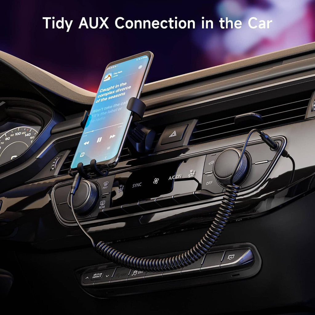 Coiled 3.5mm stereo audio cable with gold male plug connected in car AUX port