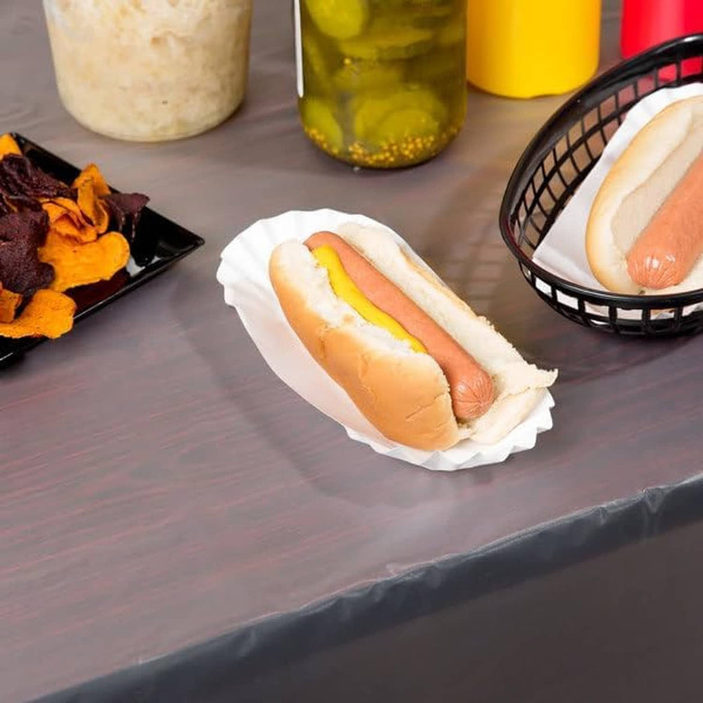 White fluted paper tray holding a hot dog with condiments
