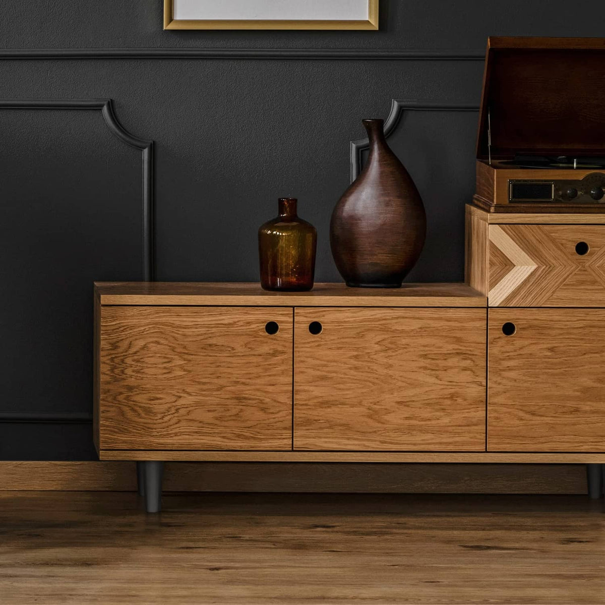 Black plastic furniture legs under a wooden sideboard