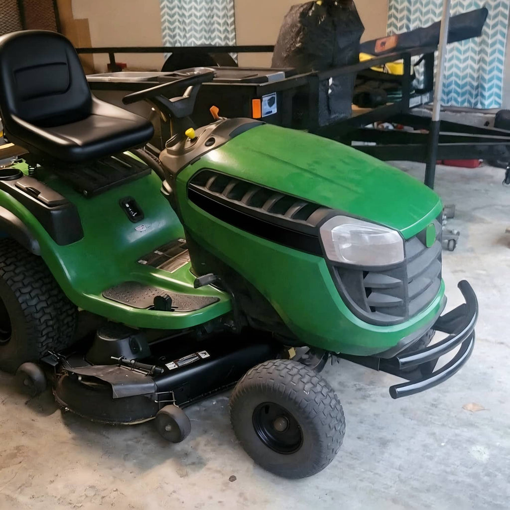 Green lawn tractor with attached black front bumper guard