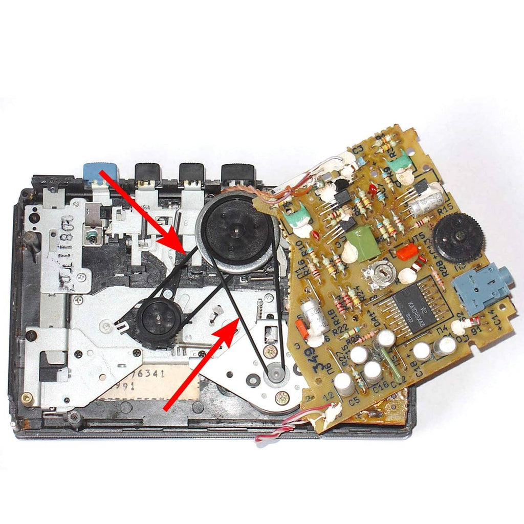 Opened cassette player mechanism with thin black drive belts and circuit board.