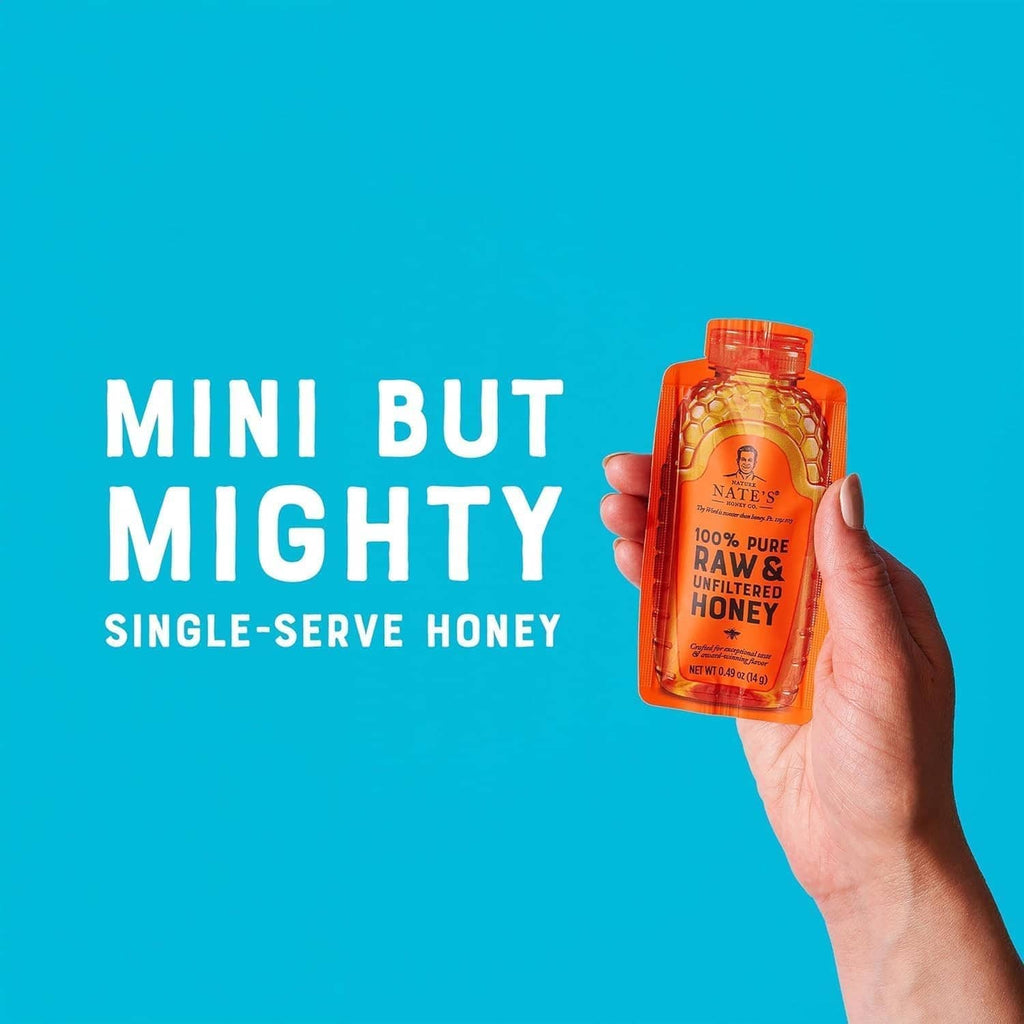 Hand holding a Nate's Honey Minis single-serve raw & unfiltered honey pouch