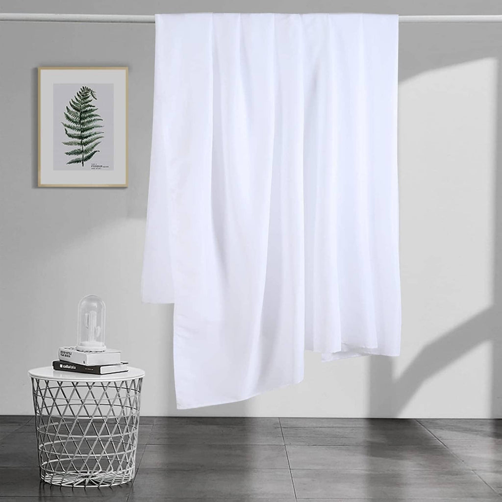 White flat sheet hanging over the bed edge with a full, even drape