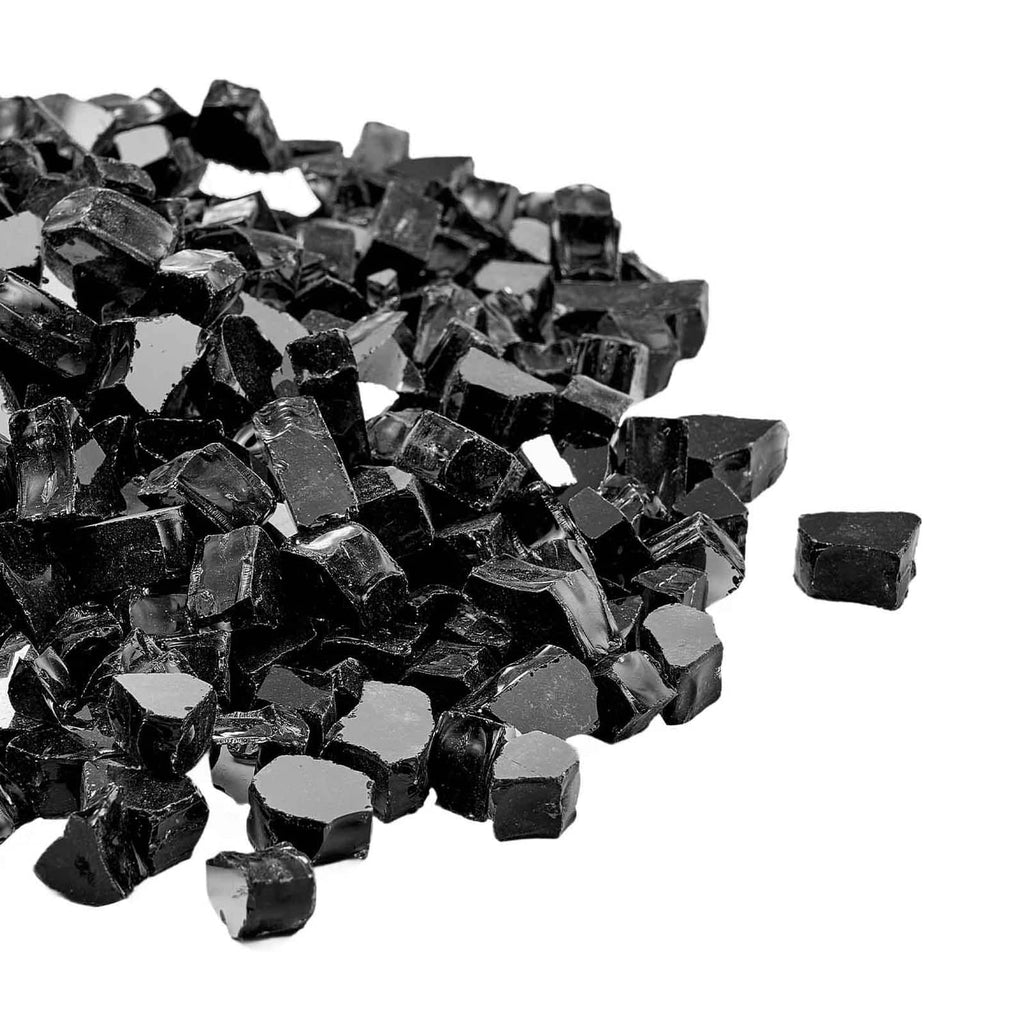Close-up of black crushed fire pit glass rocks, faceted dark cubes and shards