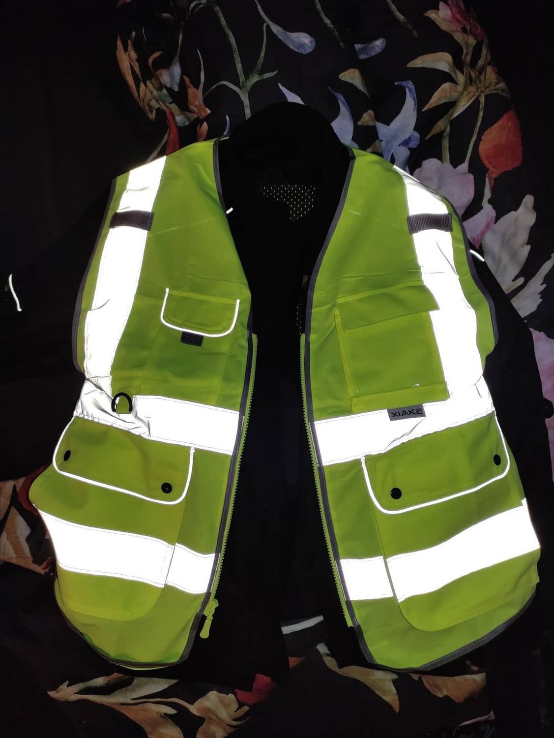 Neon yellow high-visibility vest with reflective stripes and flap pockets, front zipper