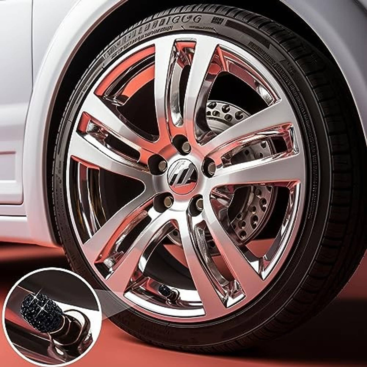 Black rhinestone tire valve cap on a chrome wheel with red accents