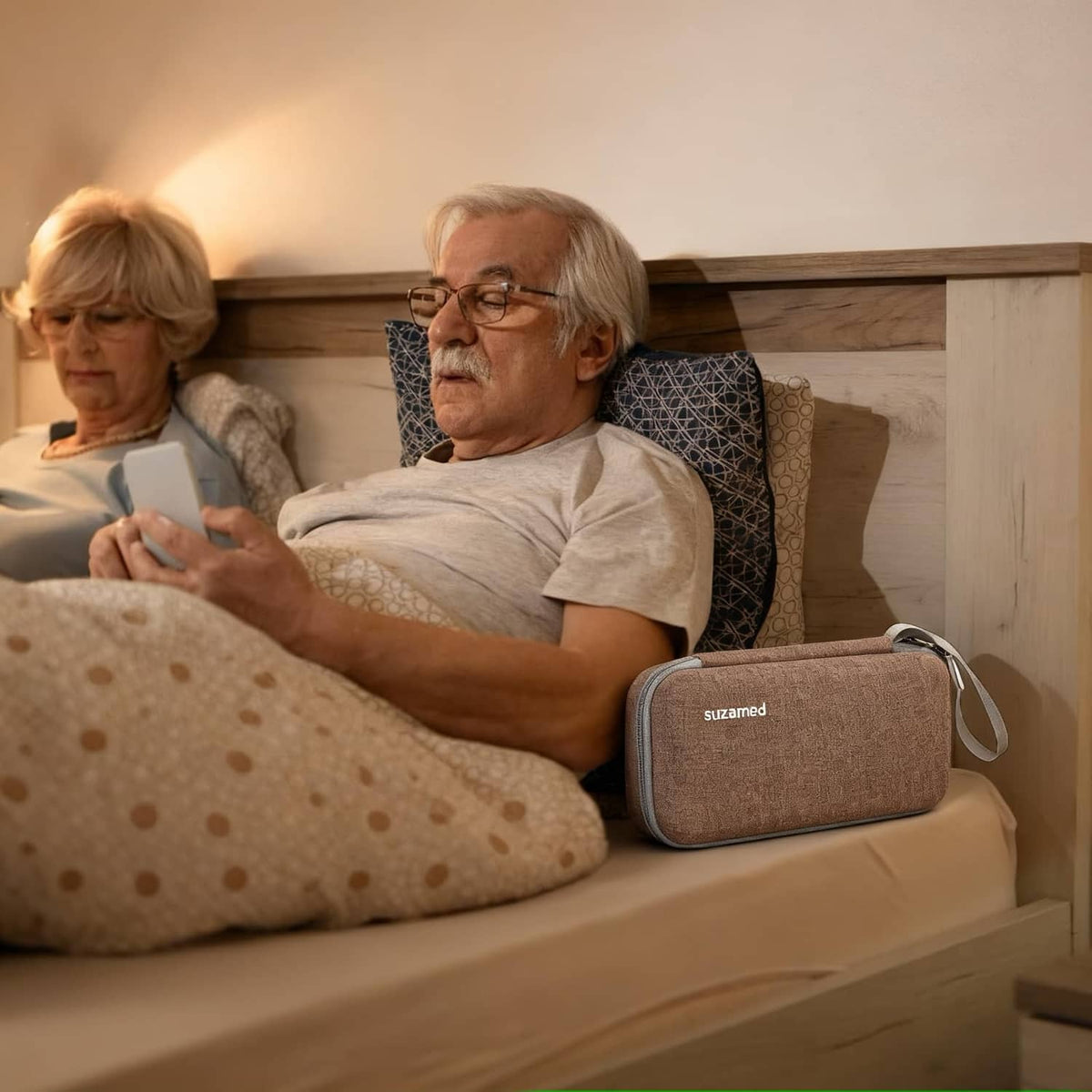 Brown insulin cooler travel case with wrist strap resting on bedside