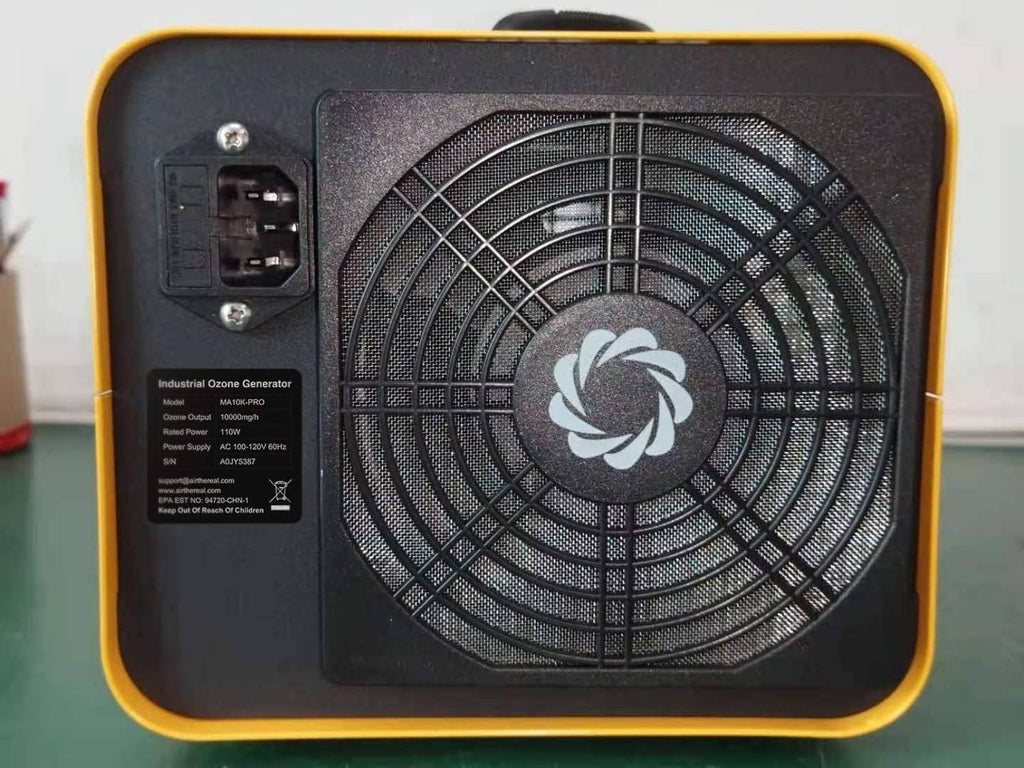 Back side of yellow ozone generator with black cooling fan grille