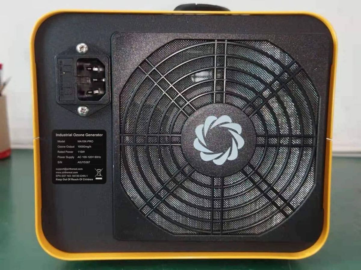 Back side of yellow ozone generator with black cooling fan grille
