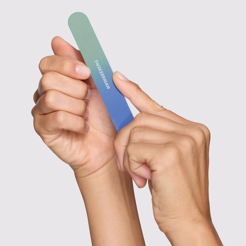Mint and blue nail file held in hand for trimming and smoothing nails