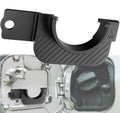 Black plastic gas cap holder trim with ridged curved grip and mounting tab