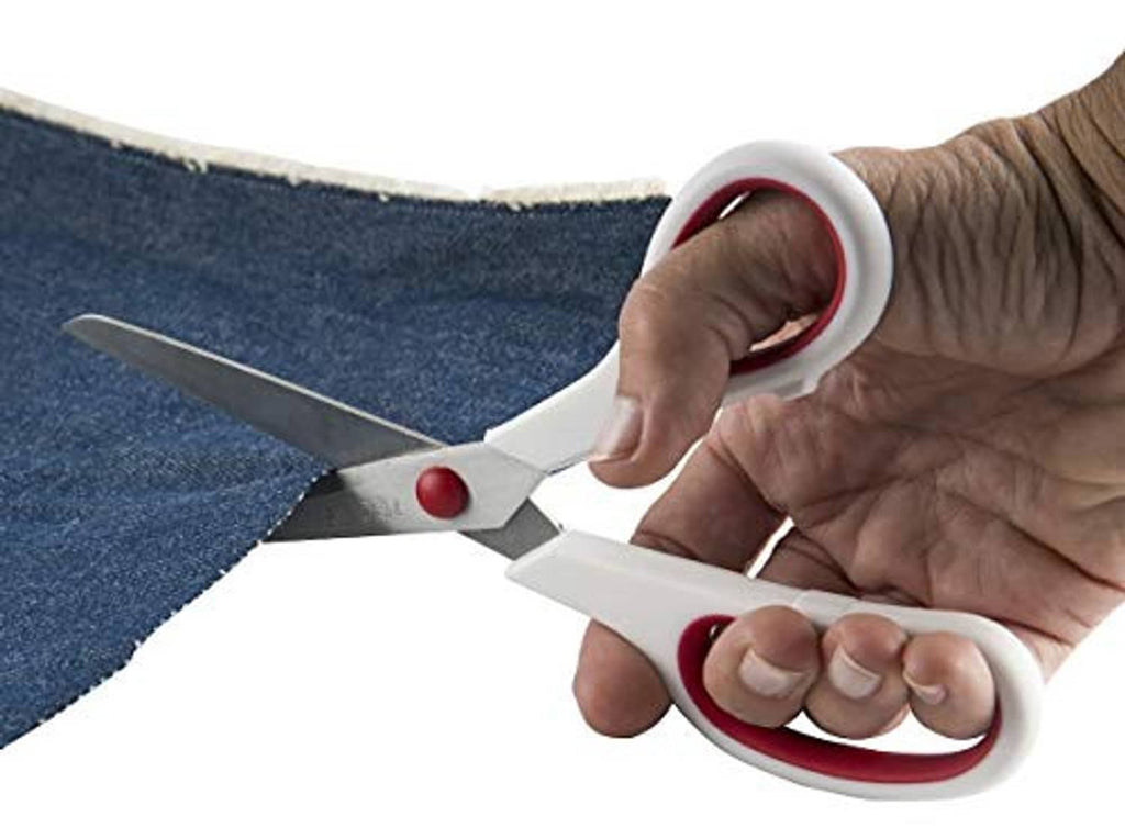 Hand holding red-and-white Singer scissors cutting dark fabric with gray blades
