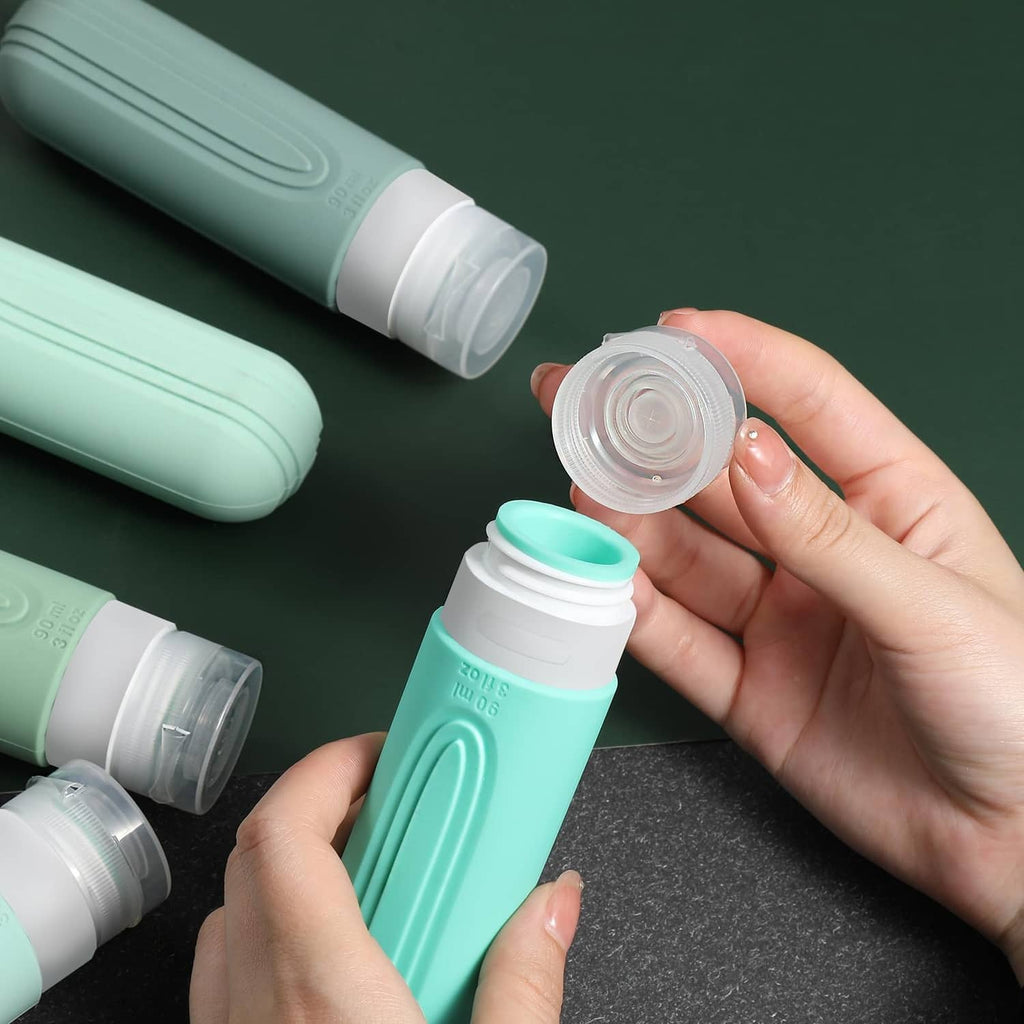 Mint green travel bottles with flip-top caps; hand holding an open screw lid