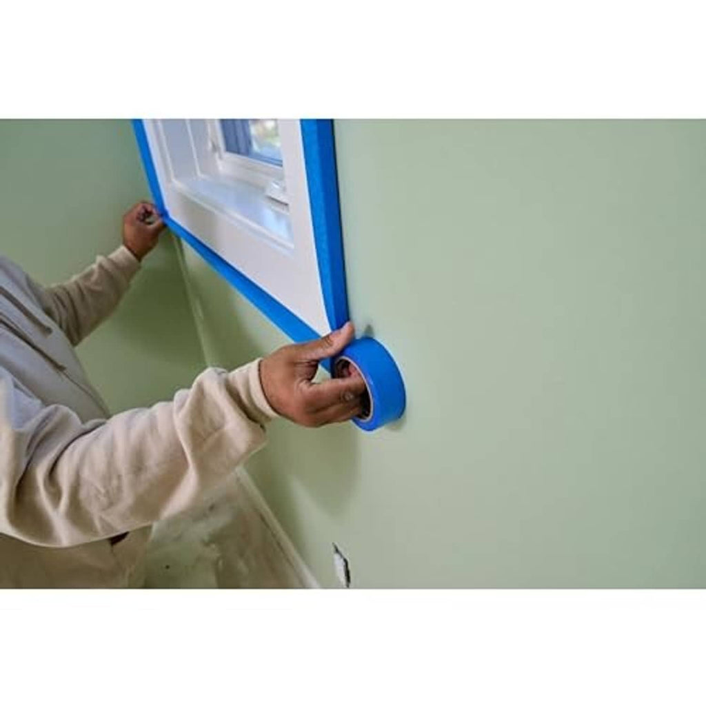 Blue painter's tape placed along window trim corner for straight lines