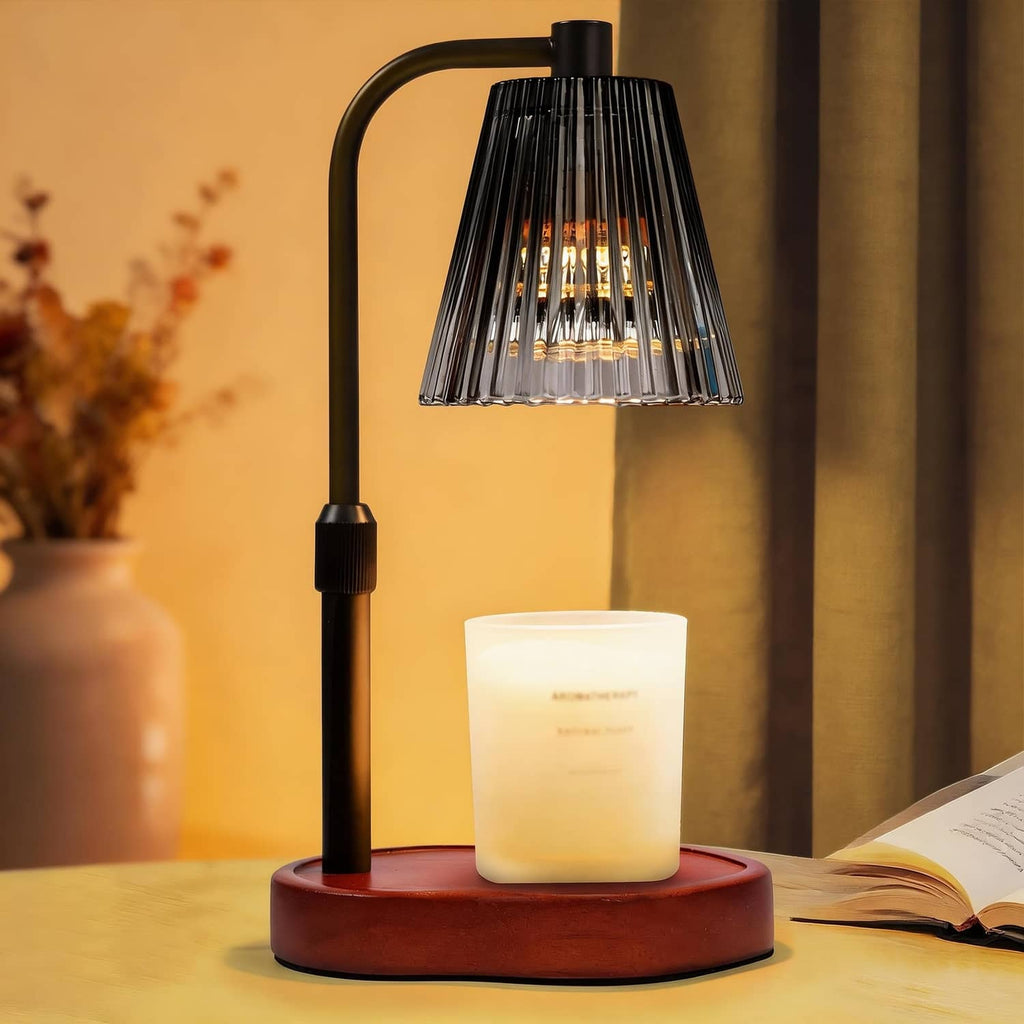Black candle warmer lamp with glass shade, warming a lit candle on a round base.