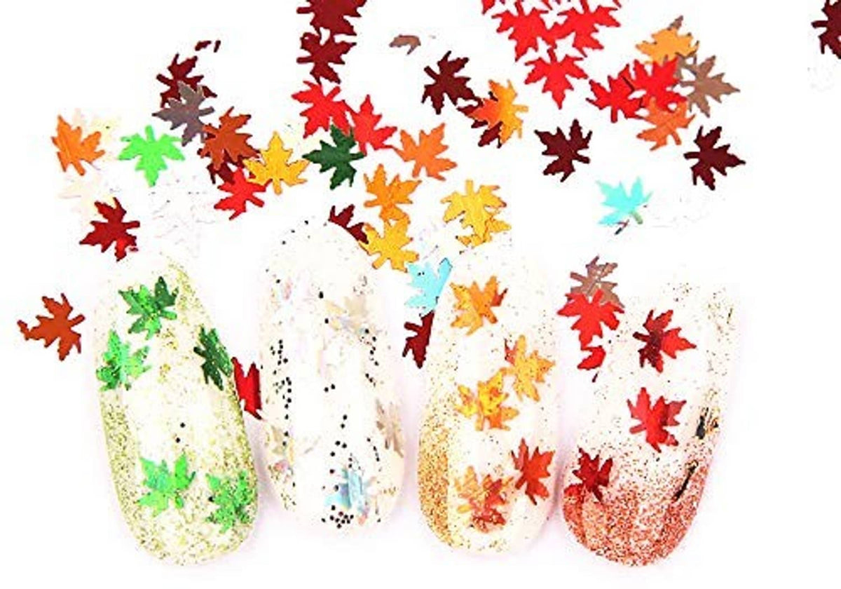Maple leaf nail glitter sequins on red, green, and gold nail art