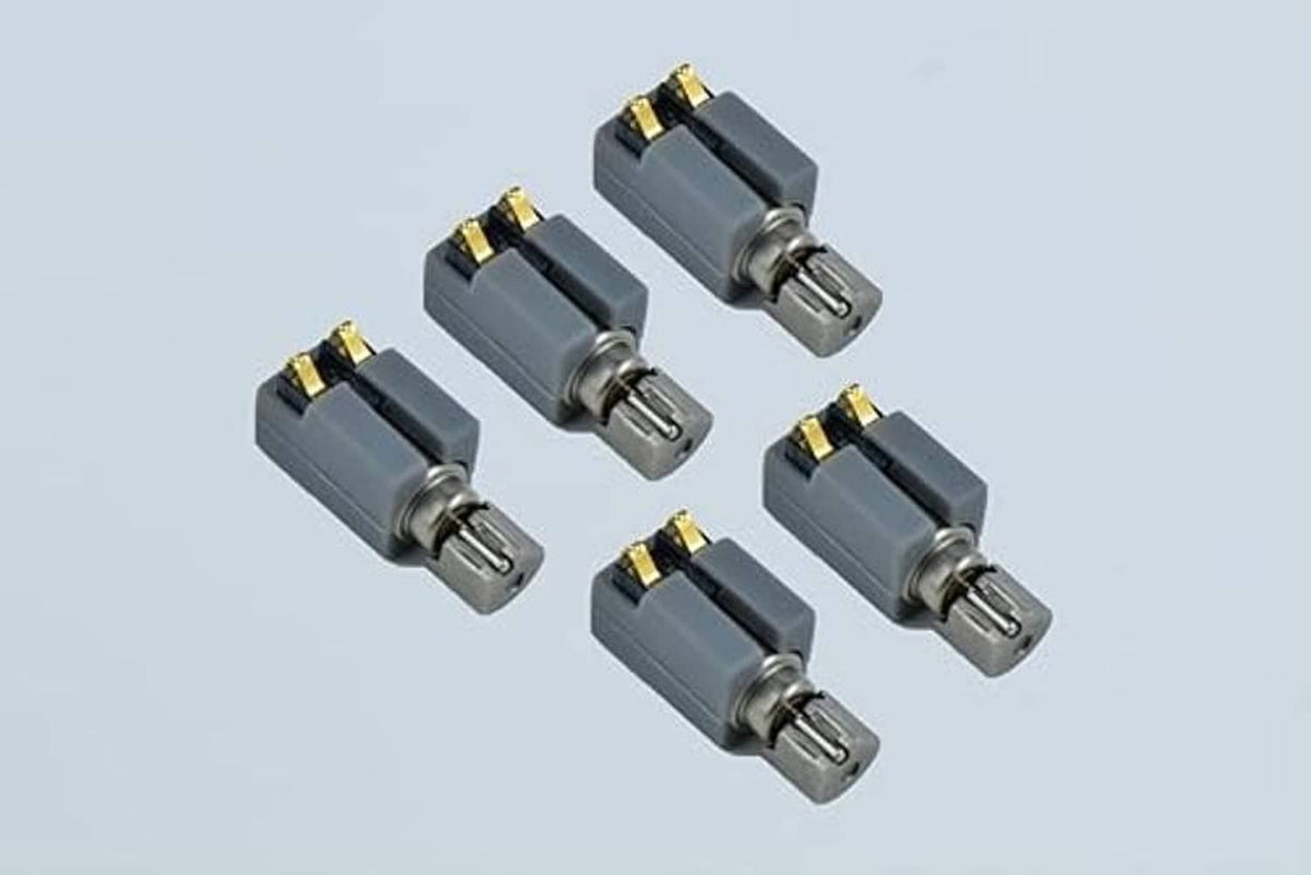 Five grey vibration motors with metal shaft and gold top terminals, angled view