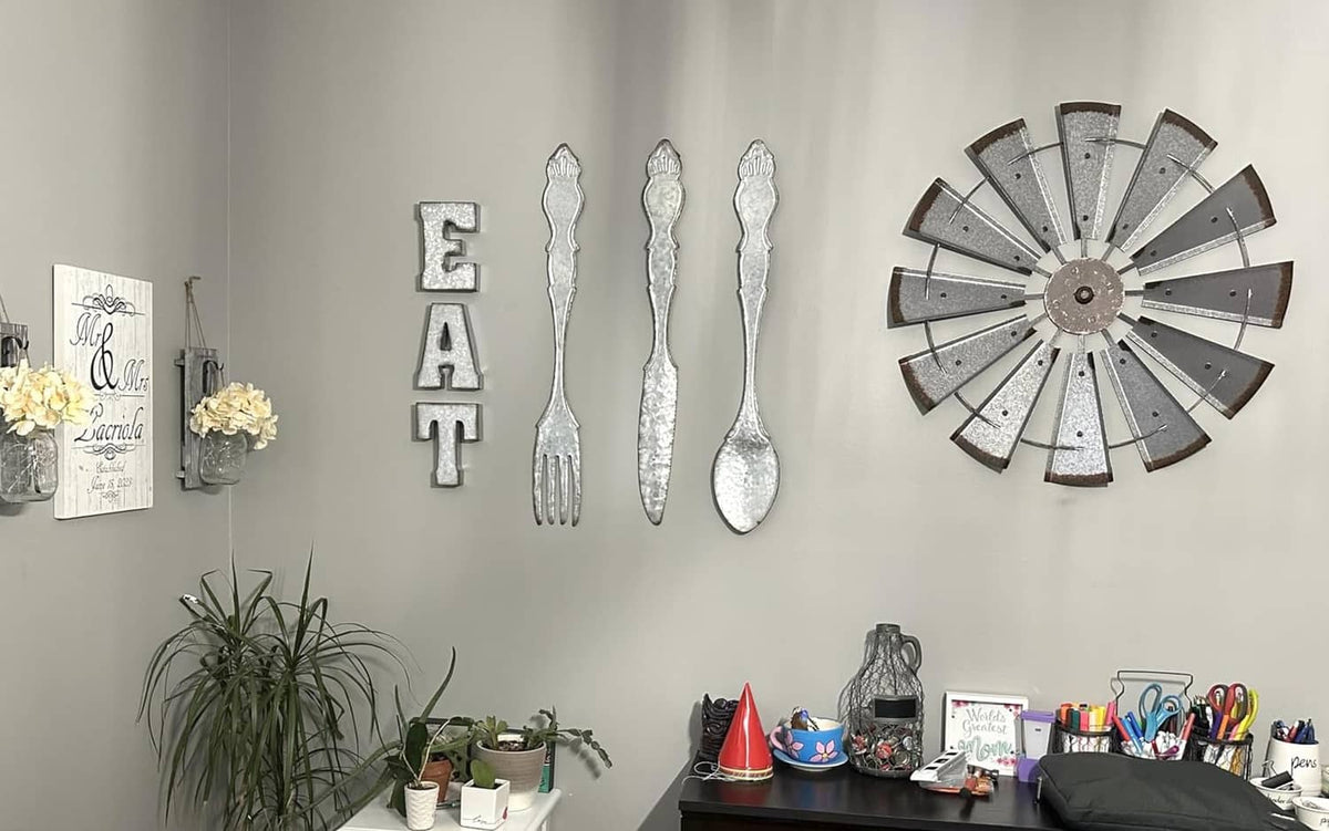 Silver EAT metal letters with distressed finish on wall near other decor