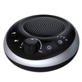 Round white noise sound machine with speaker grille and control buttons, dark casing