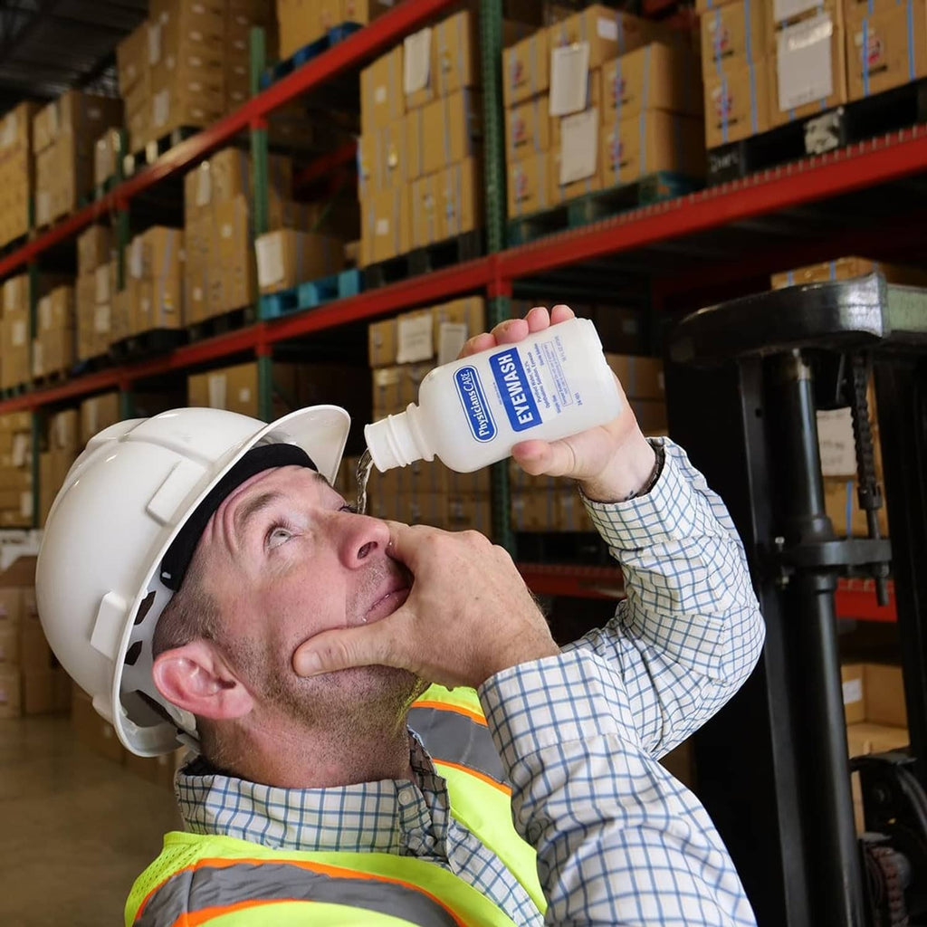 Eye wash bottle being applied to a worker wearing a hard hat