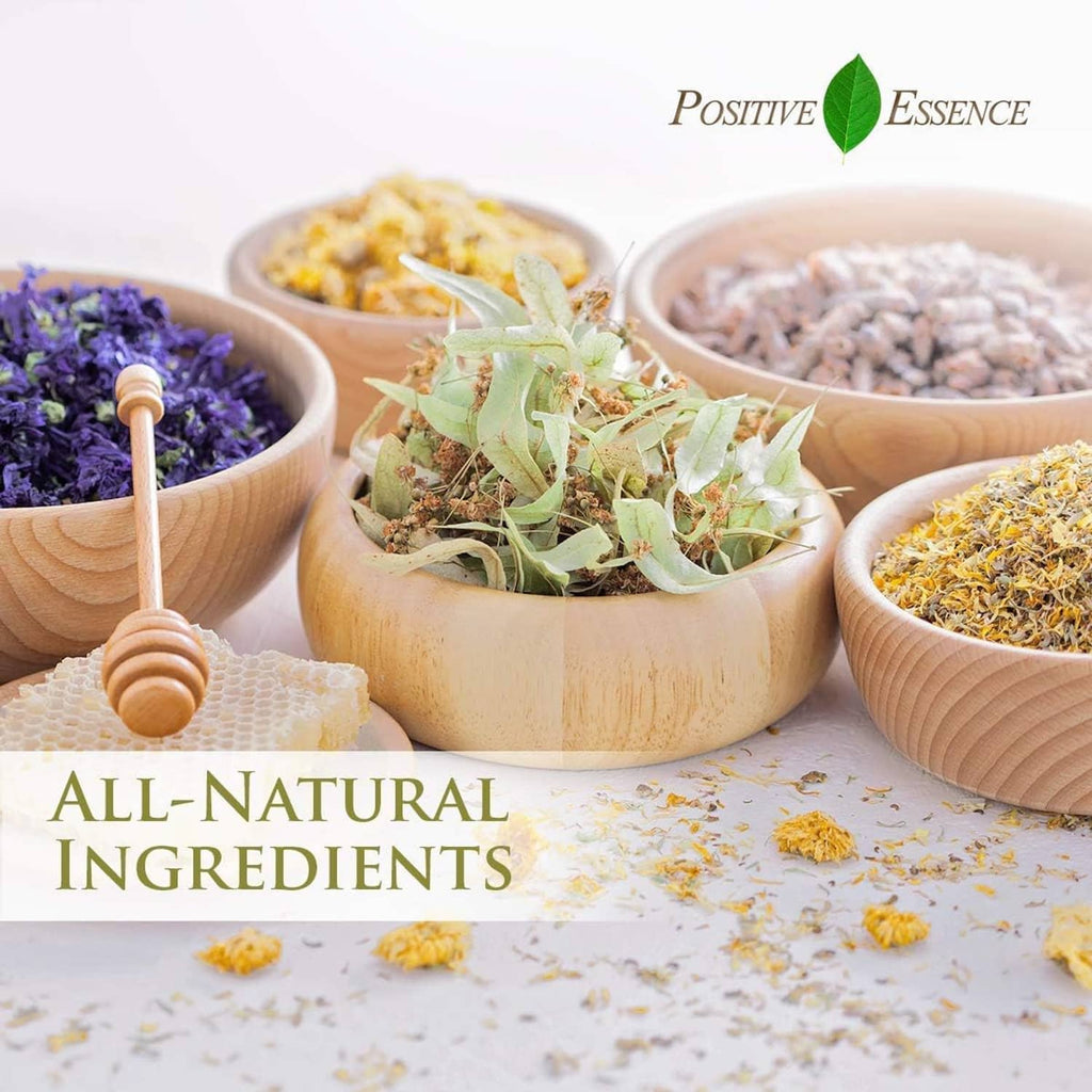 Rose absolute oil product with wooden bowls of dried botanicals in soft light