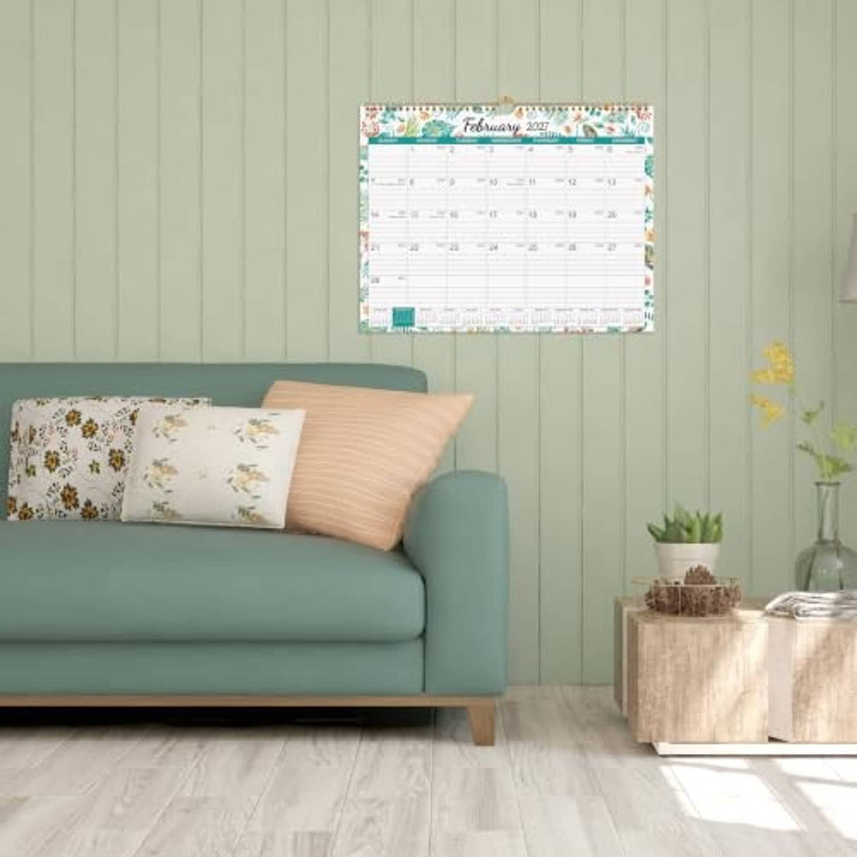 Wall calendar mounted on a wall above a sofa, showing a monthly view