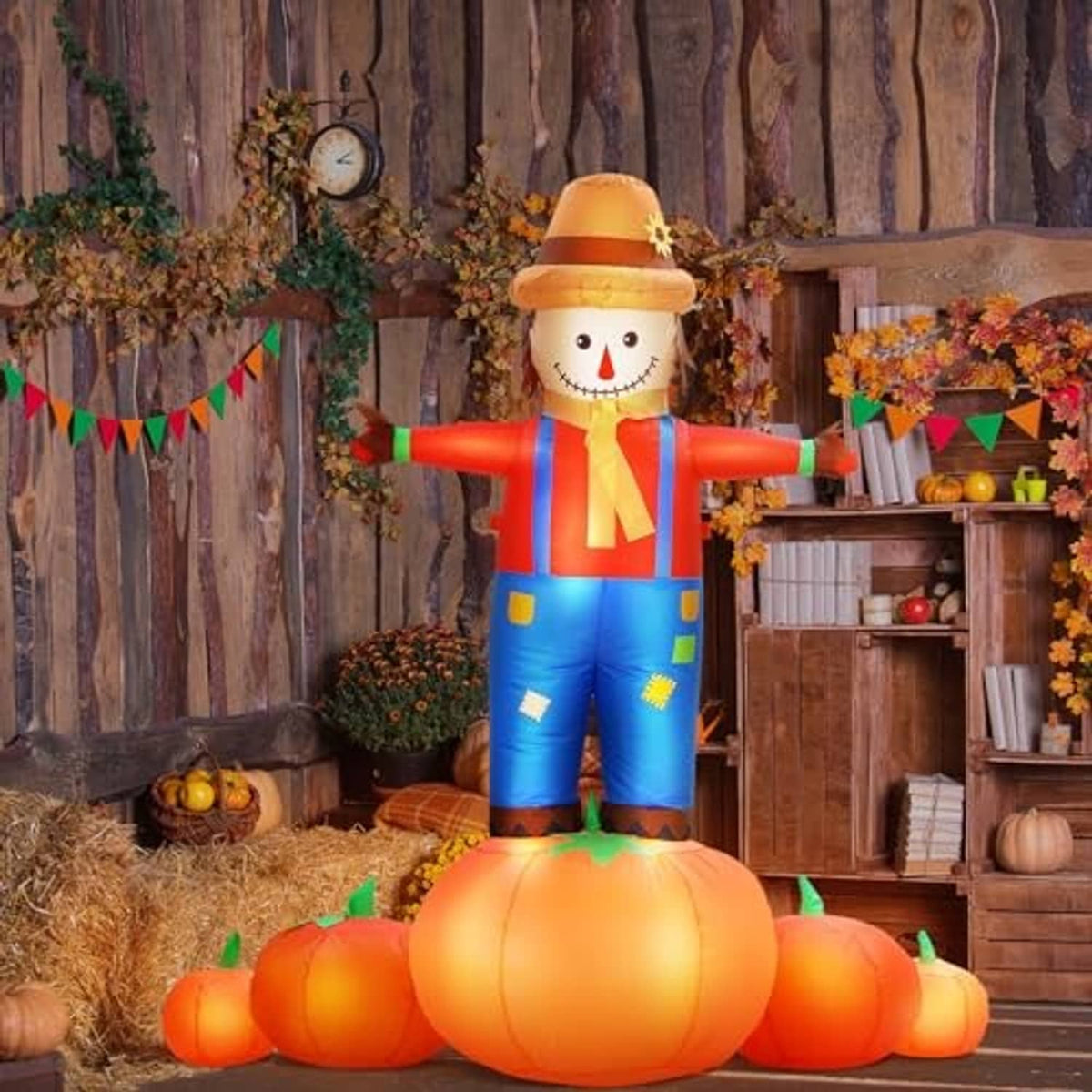Inflatable scarecrow figure with pumpkin base, red striped shirt and orange hat, garden setup