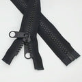 Black plastic separating zipper with double pull tabs and slider, partial length shown