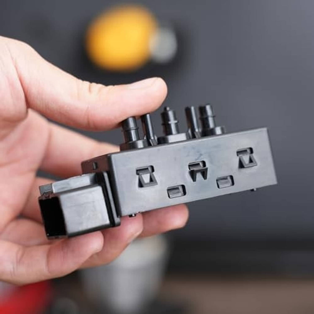 Power seat switch connector held in hand, showing front terminal openings