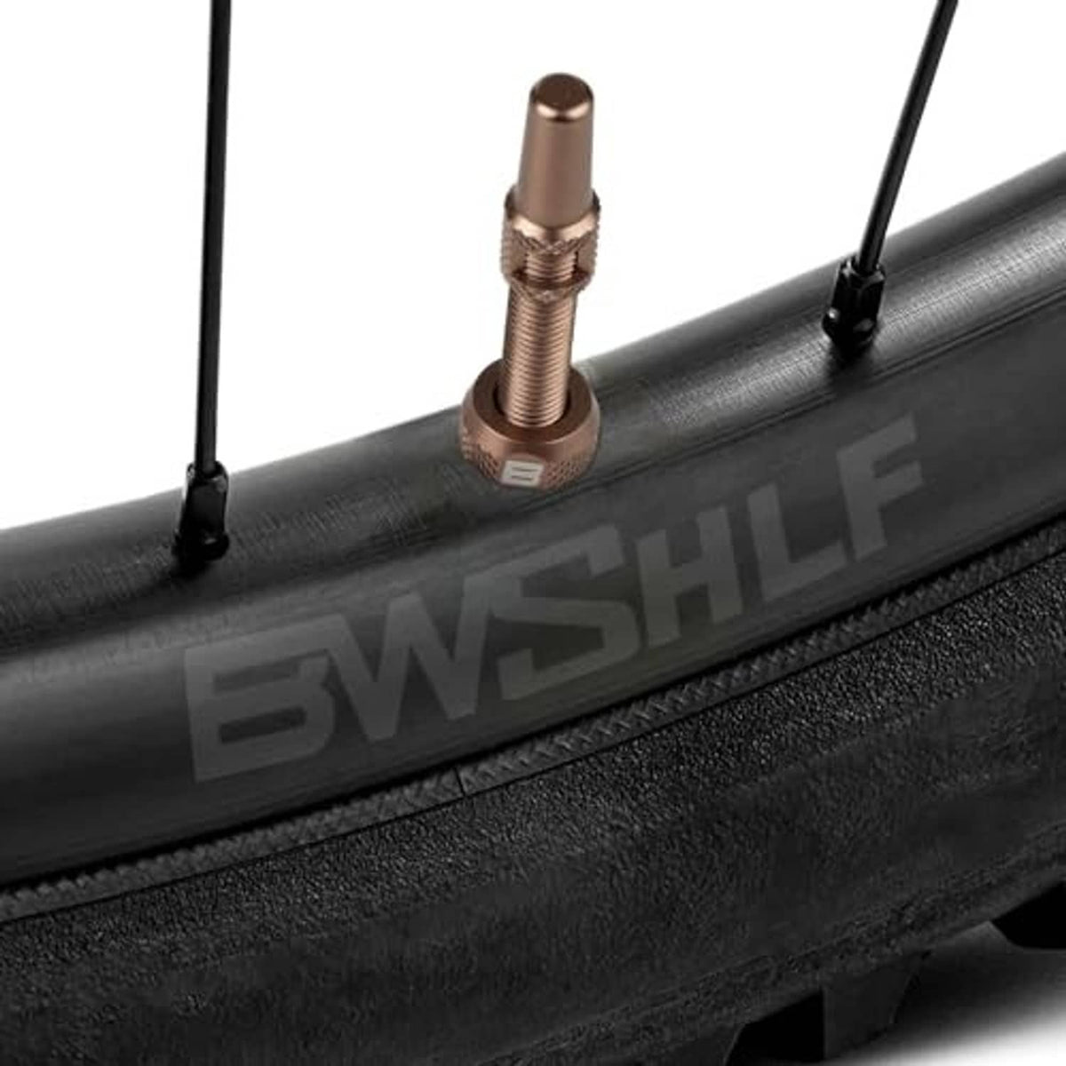 Bronze Presta tubeless valve stem installed on bicycle rim with valve base