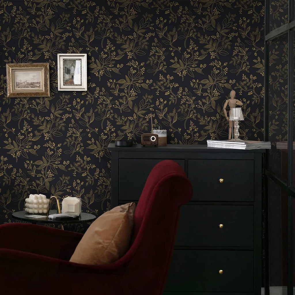 Black and gold botanical wallpaper wall with framed photos and a sideboard