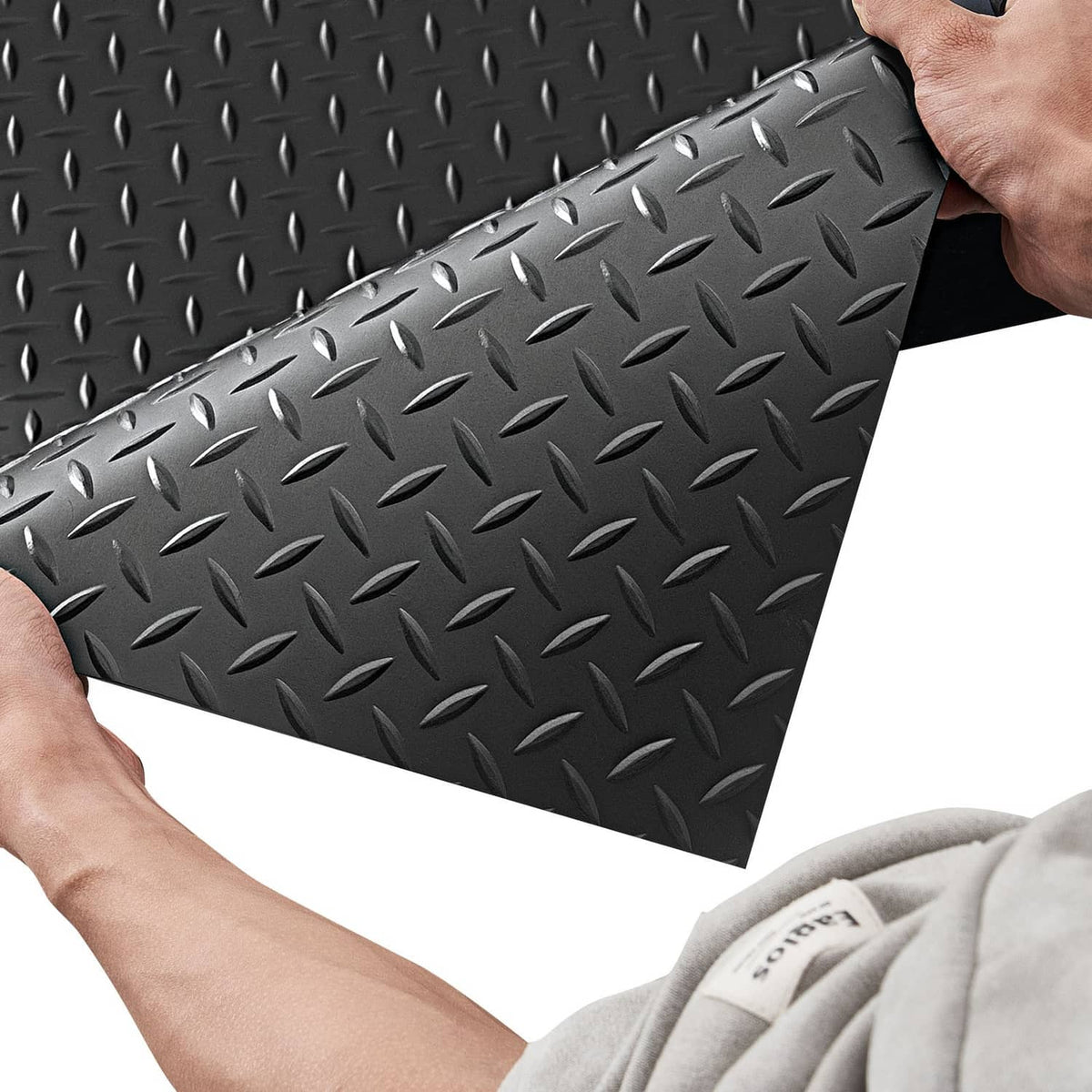 Black rubber garage floor mat with diamond-plate tread, rolled edge detail