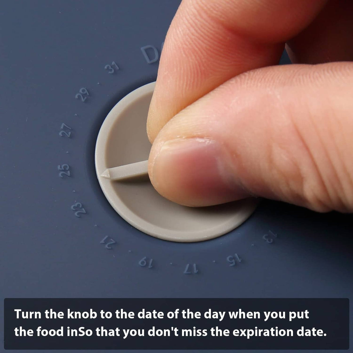 Dark blue lid with date dial and removable knob, shown being adjusted by a hand