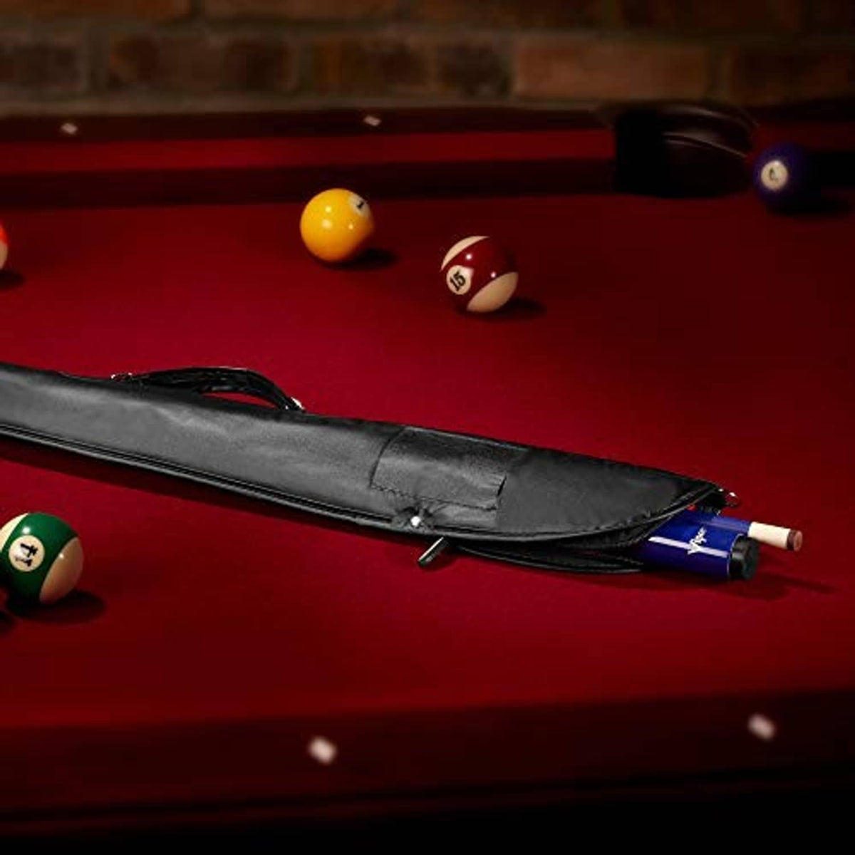 Black pool cue case with strap and zipper, partially holding a cue on a table