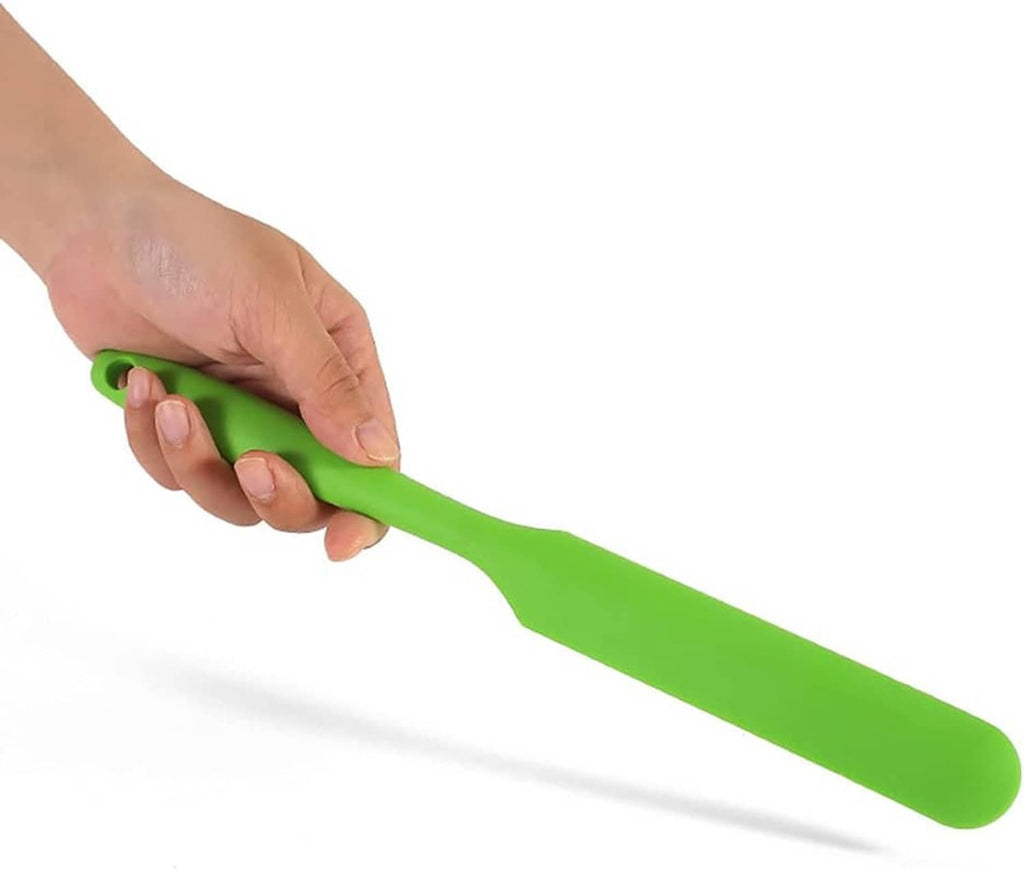 Long green silicone spatula held in hand for mixing, flexible blade