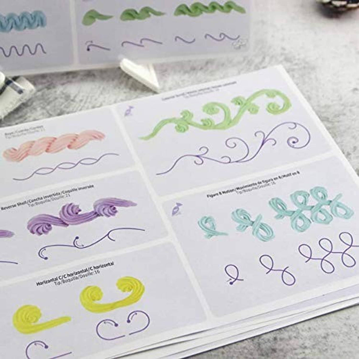 Practice board sheets showing swirls, loops, shells, and numbering for cake piping