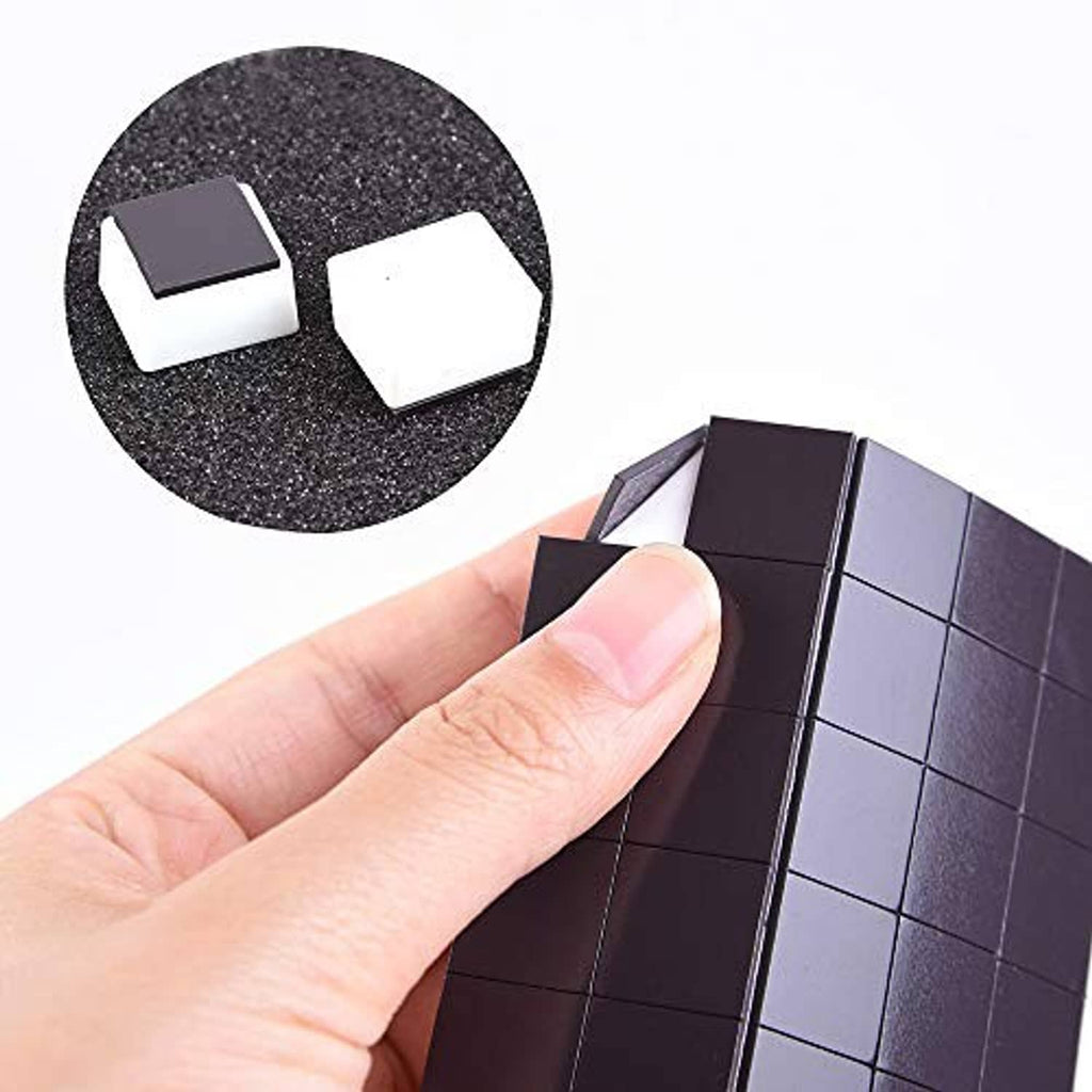 Dark magnetic watercolor half-pan sheet with empty square pans, close-up with hand
