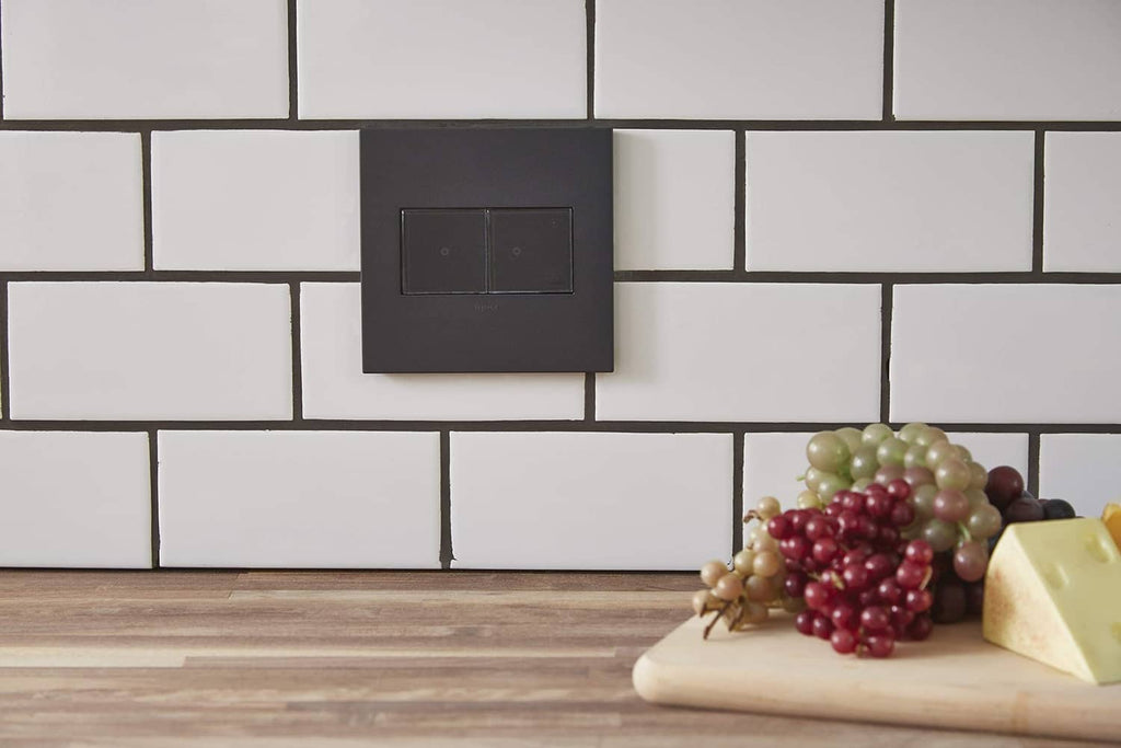 Graphite 2-gang wall plate outlet centered on a white brick-pattern backsplash