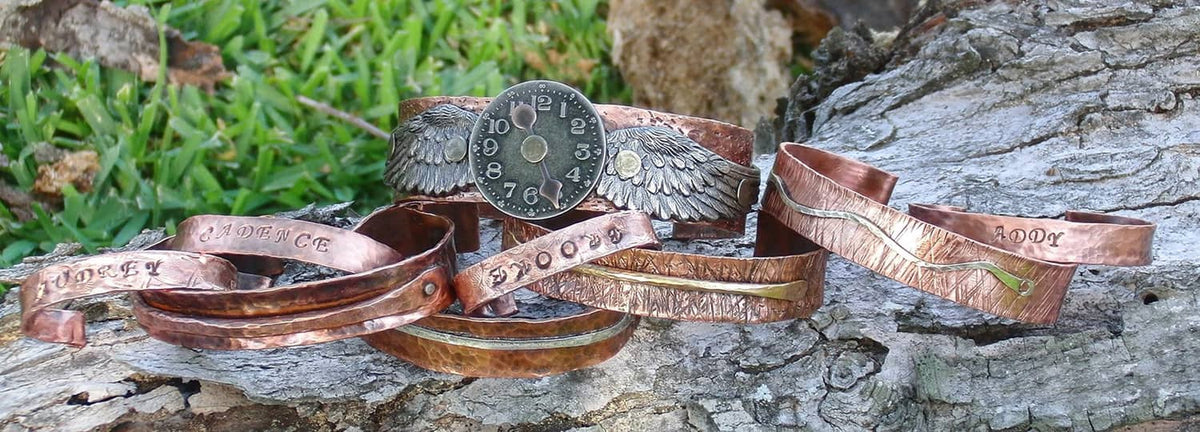 Copper-colored leather watch or bracelet straps on stone with metallic hardware