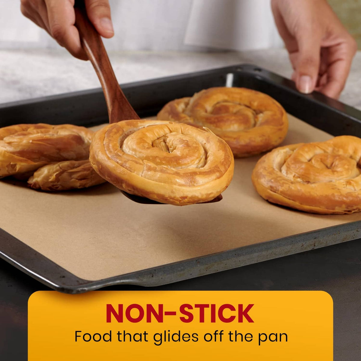 Natural brown parchment paper lining a baking tray with pastries, held by hands