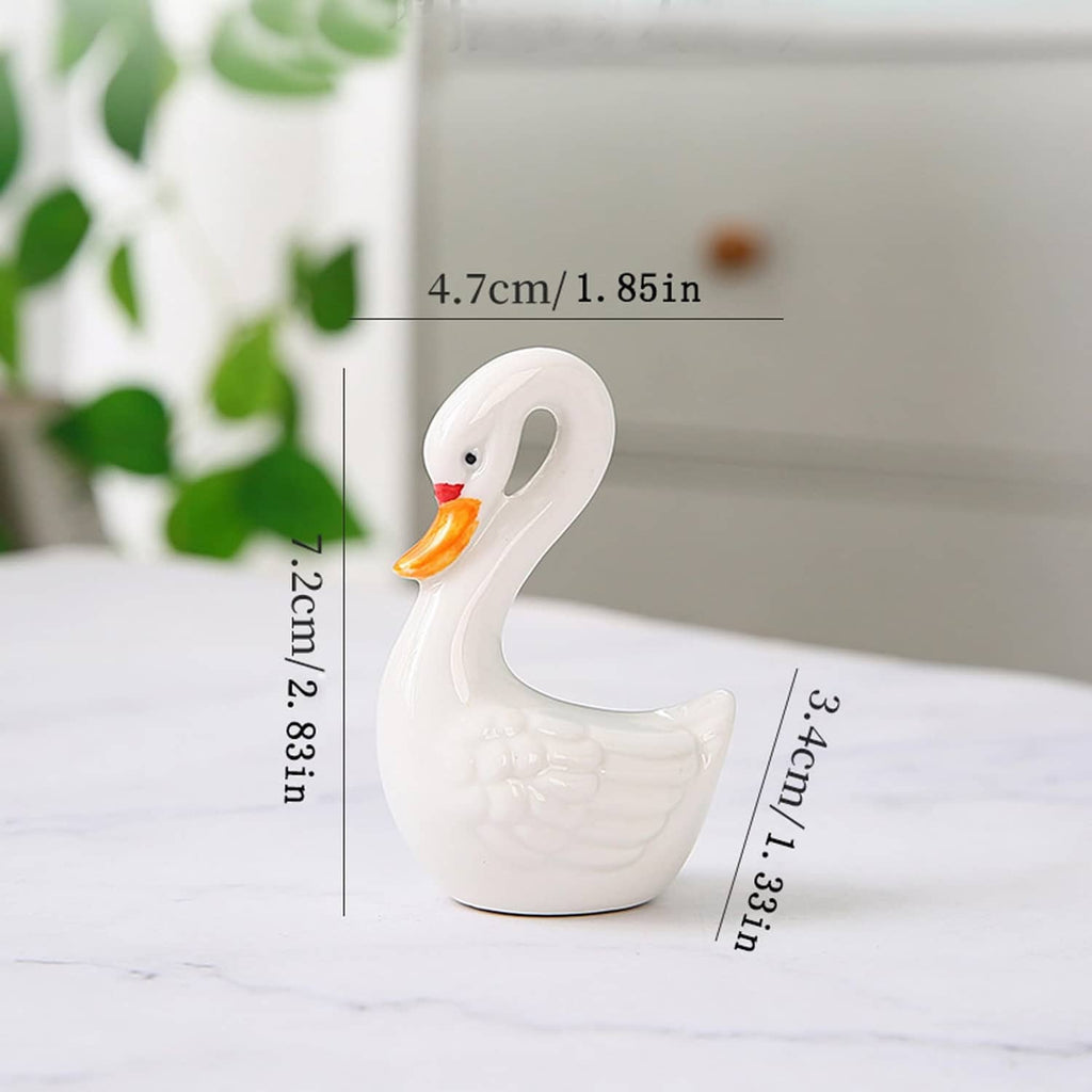 White ceramic swan figurine with orange beak and curved pose, side view