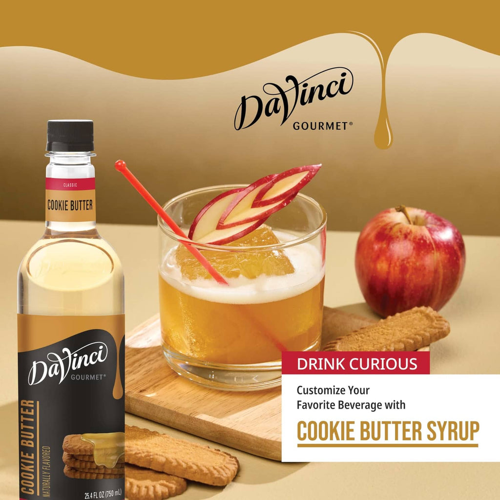 Cookie butter syrup bottle with iced drink in glass, cookies, and apple garnish