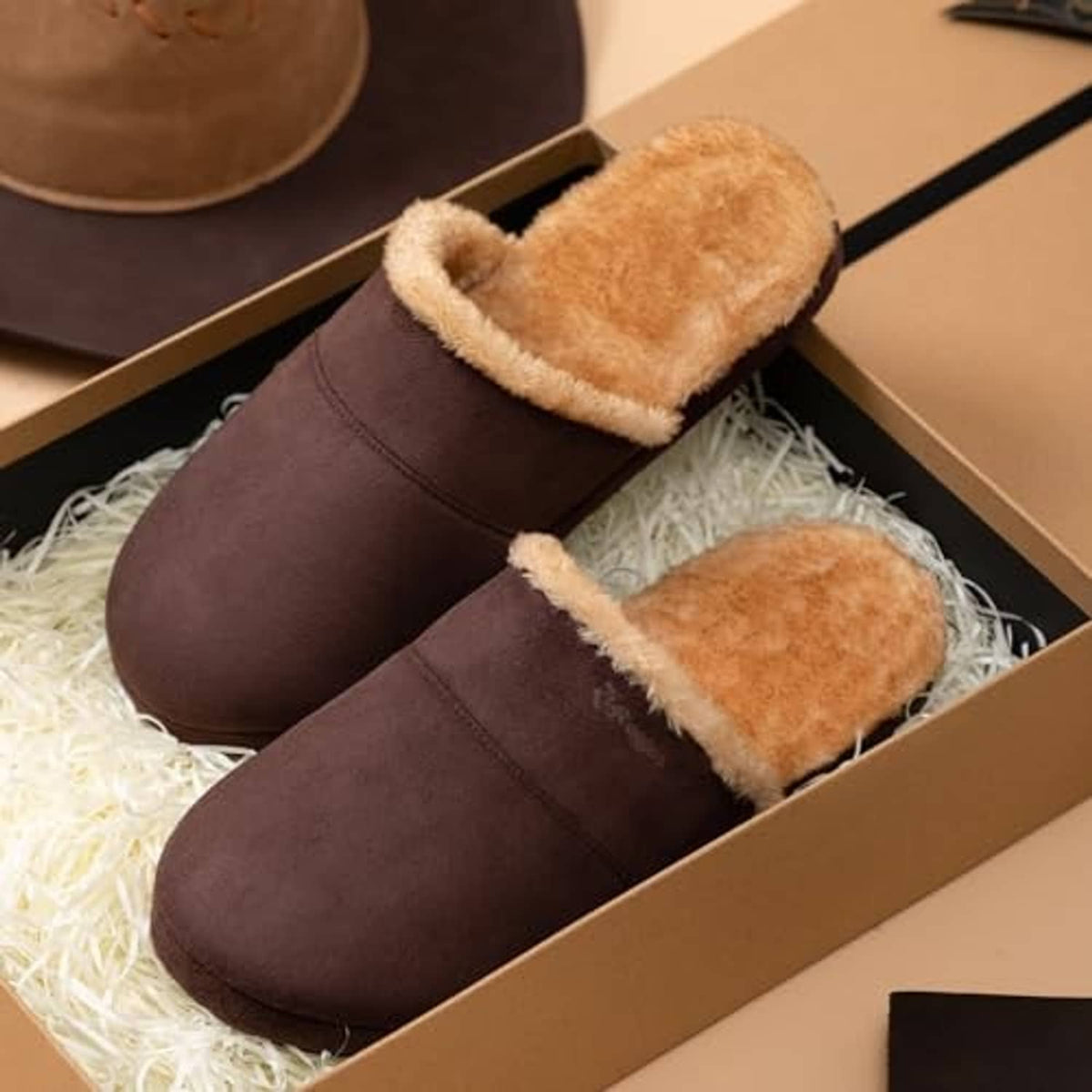 Dark brown fuzzy scuff slippers with tan lining in a shoebox
